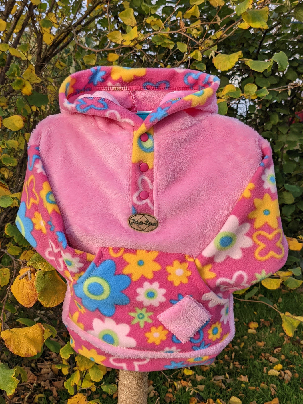 Kid's supersoft fleece hoodie with daisy pattern pocket.