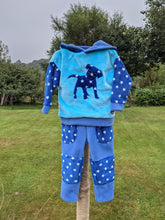 Load image into Gallery viewer, Kid&#39;s fleece dungarees in sky blue with blue stars.
